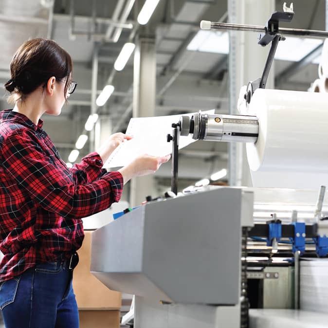 employee inspecting ream of paper